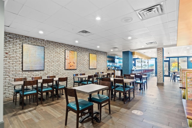 dining space with hardwood / wood-style flooring and a paneled ceiling