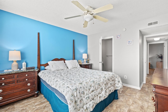 bedroom with a textured ceiling and ceiling fan