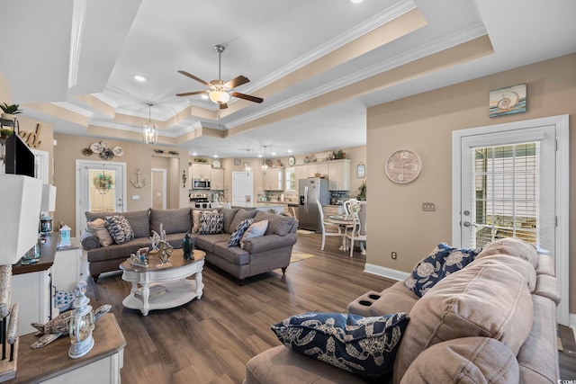 living room featuring ceiling fan, ornamental molding, dark hardwood / wood-style floors, and a tray ceiling