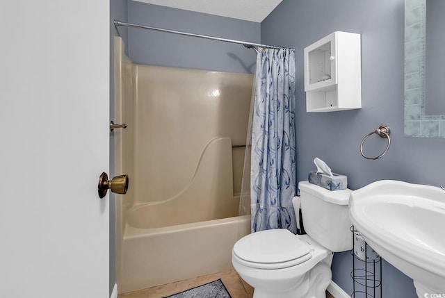 full bathroom with shower / bath combo, tile flooring, sink, toilet, and a textured ceiling