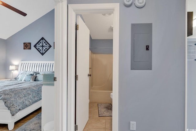 bedroom with connected bathroom, ceiling fan, lofted ceiling, and light tile floors