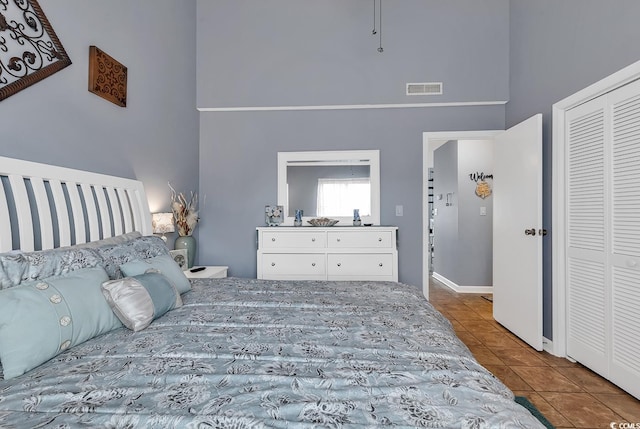 tiled bedroom featuring a closet and a towering ceiling