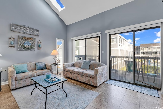 living room with a wealth of natural light, a skylight, and light tile floors