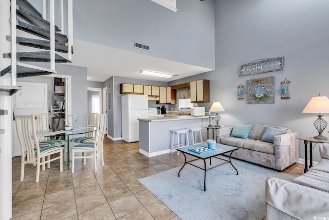 tiled living room featuring a high ceiling