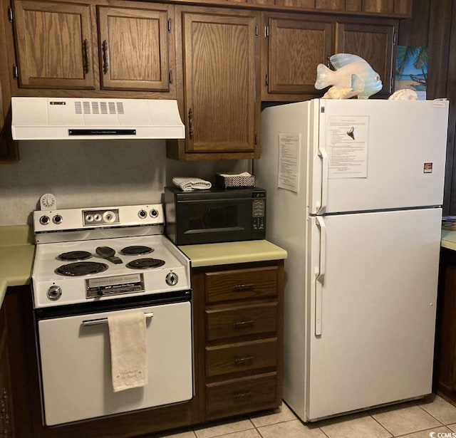 kitchen featuring light tile flooring, white appliances, and extractor fan