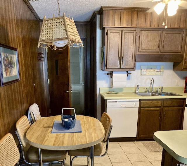 kitchen featuring ceiling fan, light tile floors, dishwasher, a textured ceiling, and sink