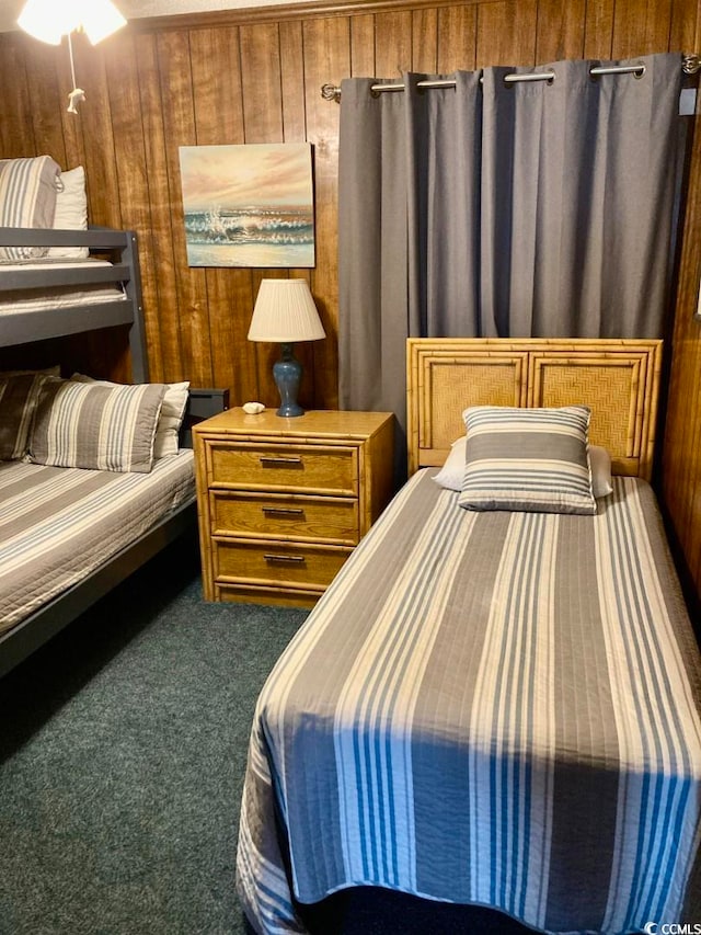 carpeted bedroom featuring wood walls