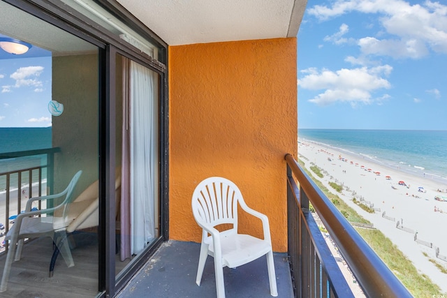 balcony featuring a view of the beach and a water view