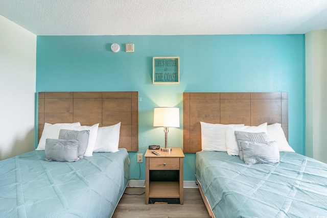 bedroom with a textured ceiling and light wood-type flooring