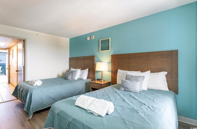 bedroom with wood-type flooring and a textured ceiling