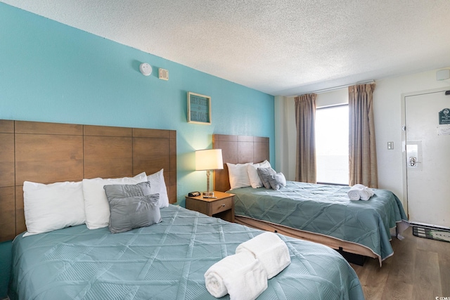 bedroom with a textured ceiling and wood-type flooring