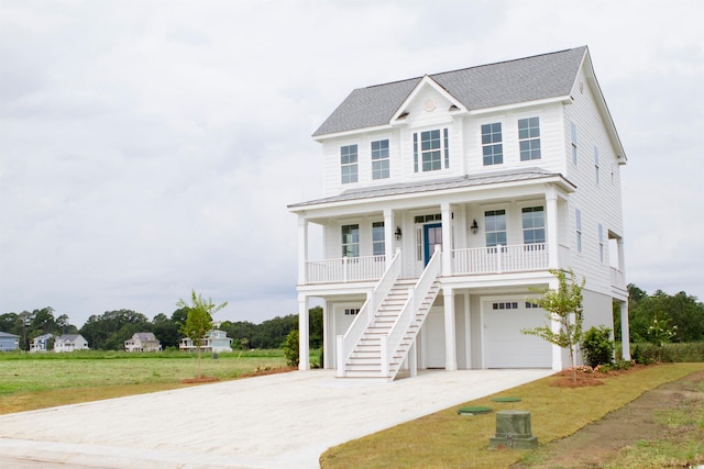 raised beach house with a front lawn, a porch, and a garage