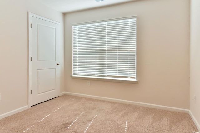 empty room with light colored carpet and a wealth of natural light