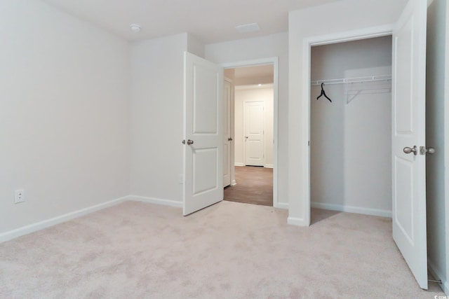 unfurnished bedroom featuring a closet and light colored carpet