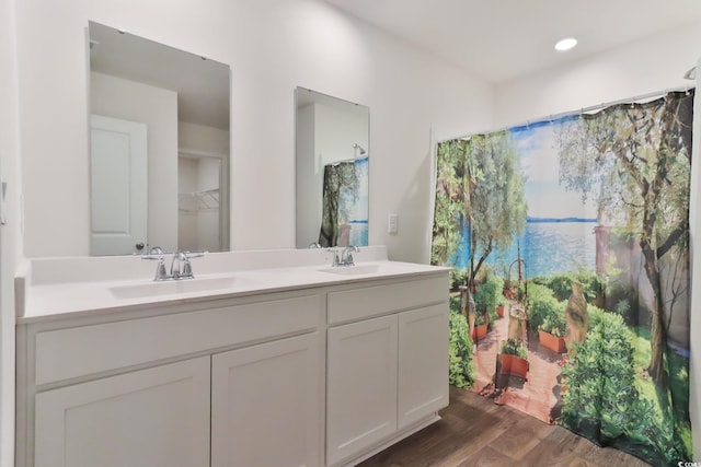 bathroom with hardwood / wood-style flooring and dual bowl vanity