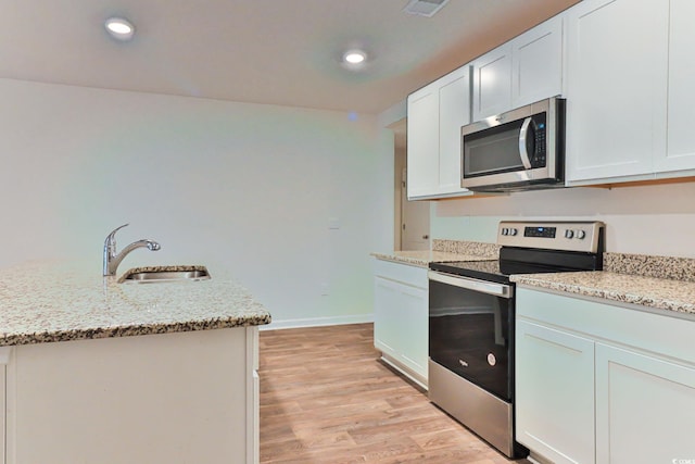 kitchen with white cabinetry, sink, appliances with stainless steel finishes, and light hardwood / wood-style flooring