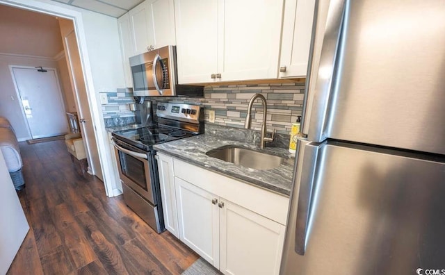 kitchen featuring white cabinetry, appliances with stainless steel finishes, sink, backsplash, and dark hardwood / wood-style flooring