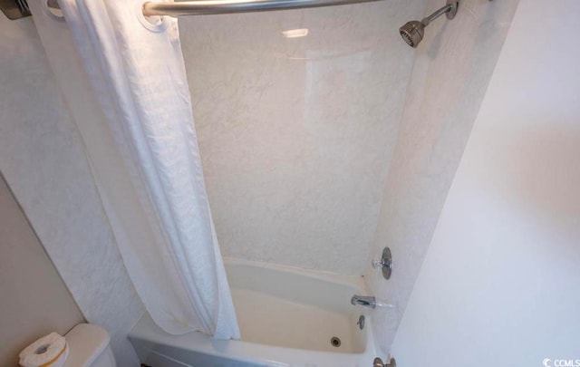 bathroom featuring toilet and shower / tub combo with curtain