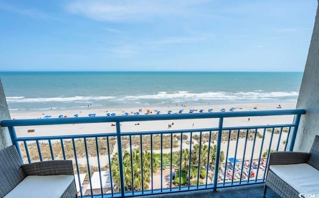 balcony with a water view and a view of the beach