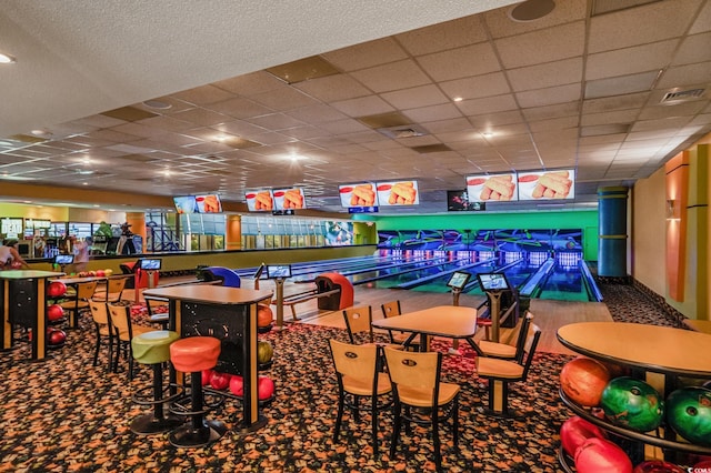 game room with carpet, a paneled ceiling, and a bowling alley