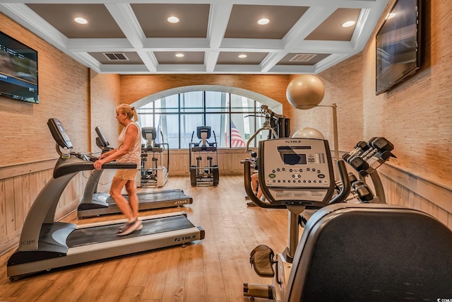 exercise room featuring light hardwood / wood-style flooring and coffered ceiling