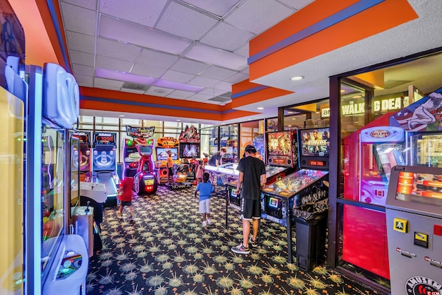 game room featuring a drop ceiling and dark colored carpet