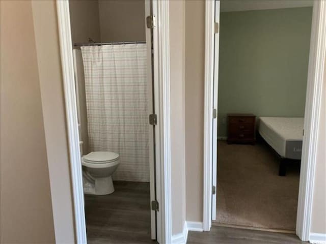 bathroom with hardwood / wood-style flooring and toilet