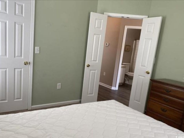 bedroom featuring hardwood / wood-style flooring and ensuite bathroom