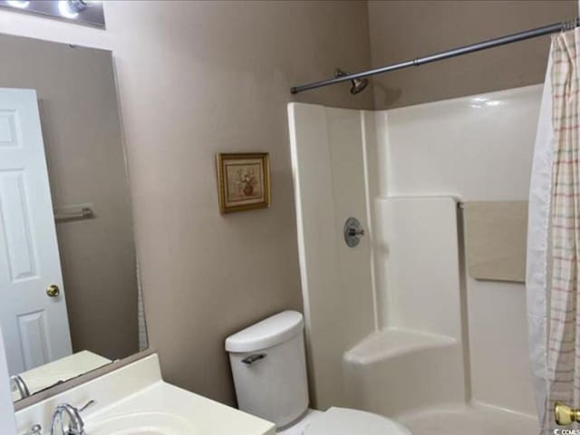 bathroom featuring toilet and a shower with shower curtain