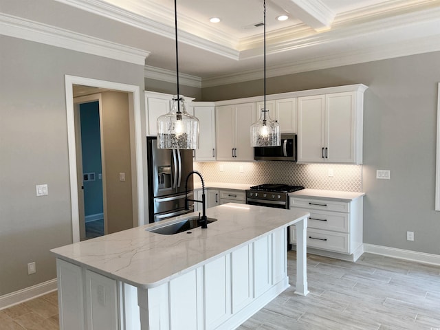 kitchen with white cabinets, appliances with stainless steel finishes, backsplash, and a kitchen island with sink