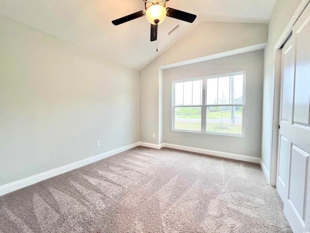 unfurnished bedroom with a closet, ceiling fan, carpet, and lofted ceiling