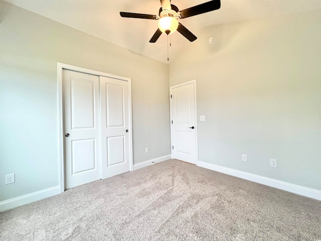 unfurnished bedroom with lofted ceiling, carpet flooring, a closet, and ceiling fan