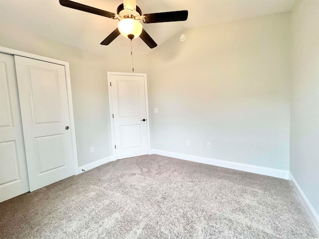 unfurnished bedroom featuring a closet, ceiling fan, carpet, and lofted ceiling