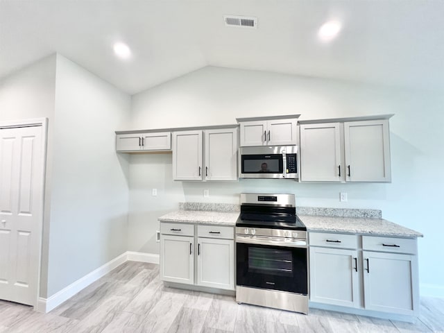 1424 Nathan Dr, Loris, SC 29569 - kitchen with appliances with stainless steel finishes, light stone counters, visible vents, baseboards, and vaulted ceiling