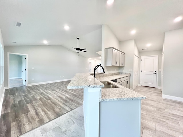 1424 Nathan Dr, Loris, SC 29569 - kitchen featuring light stone counters, a sink, a ceiling fan, baseboards, and a peninsula