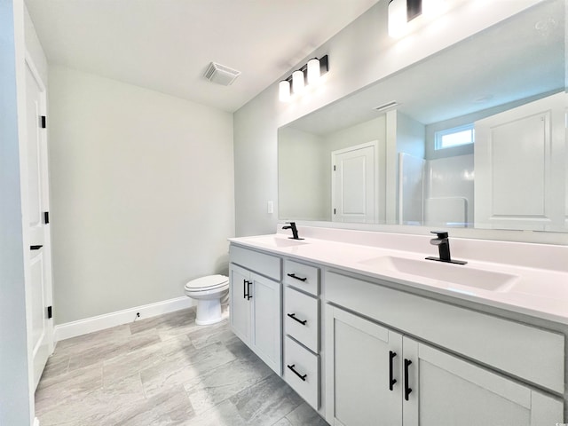 bathroom with vanity, toilet, and walk in shower