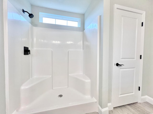 bathroom with walk in shower and wood-type flooring