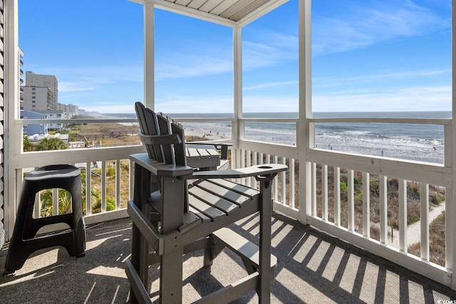 sunroom with a beach view and a water view