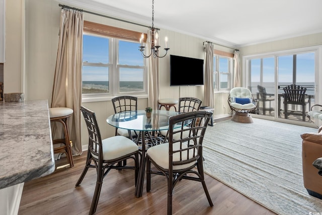 dining room with a wealth of natural light, dark hardwood / wood-style floors, and an inviting chandelier