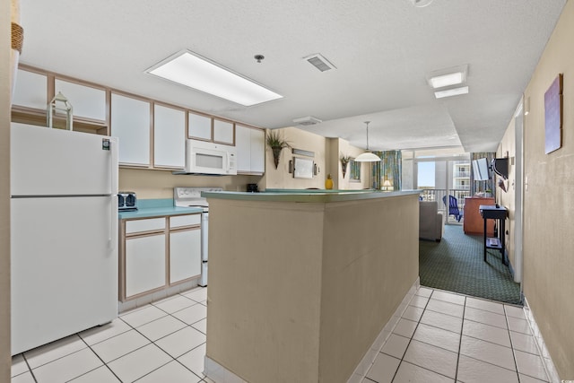 kitchen featuring pendant lighting, light tile floors, a textured ceiling, white appliances, and white cabinets