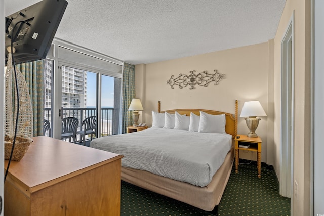 carpeted bedroom featuring access to exterior and a textured ceiling