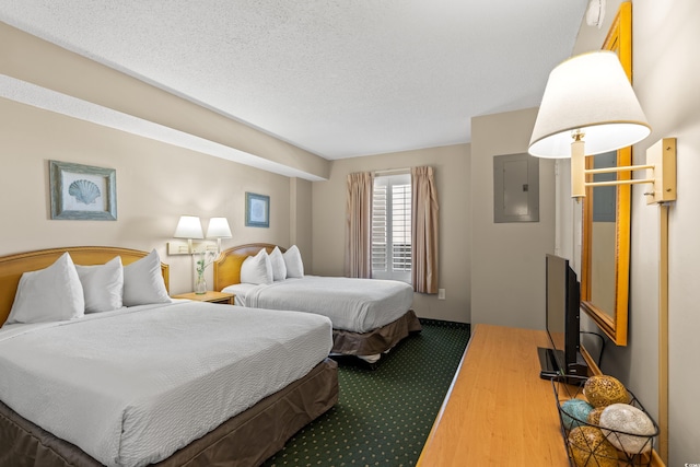 bedroom with dark hardwood / wood-style flooring and a textured ceiling