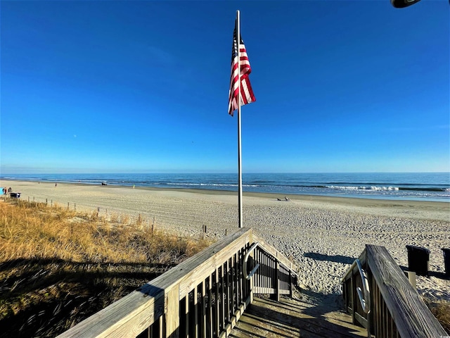 view of home's community featuring a beach view and a water view