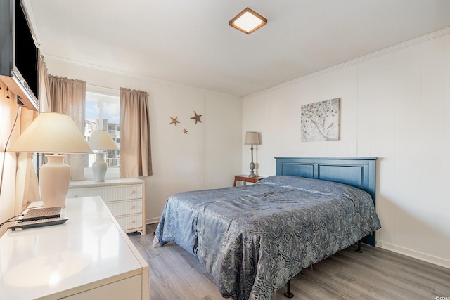 bedroom with crown molding and light hardwood / wood-style floors