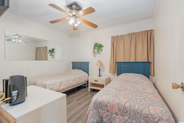 bedroom featuring crown molding, light hardwood / wood-style flooring, and ceiling fan