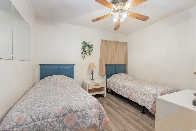 bedroom featuring crown molding, ceiling fan, and light hardwood / wood-style floors