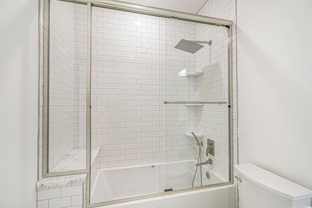 bathroom with bath / shower combo with glass door and toilet