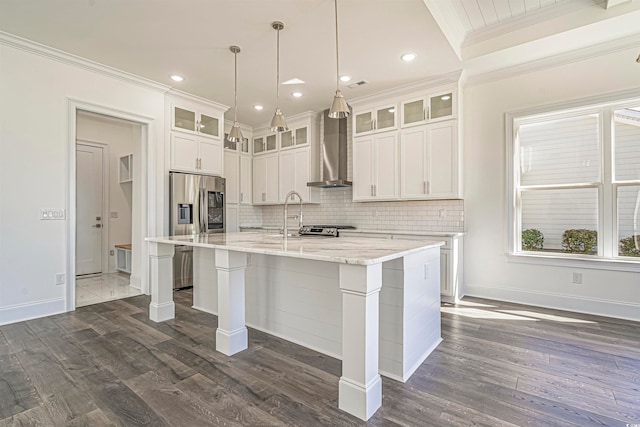 kitchen featuring white cabinetry, wall chimney exhaust hood, dark wood-type flooring, crown molding, and a kitchen island with sink