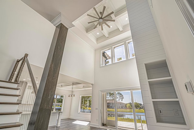 interior space featuring hardwood / wood-style floors, coffered ceiling, and a high ceiling