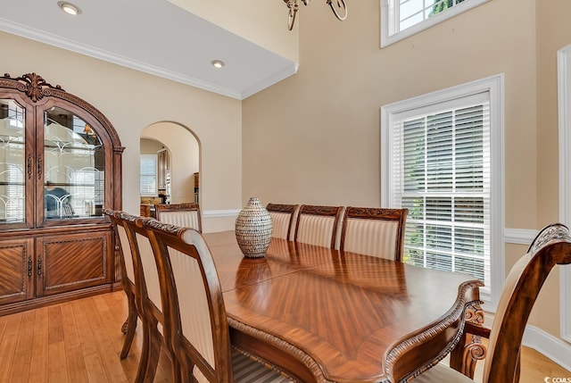 dining space with ornamental molding and light wood-type flooring